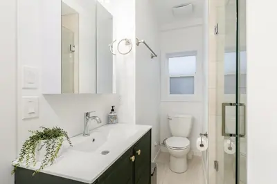 a white bathroom with a sink and a toilet at Vancouver Central Green Studio in Vancouver