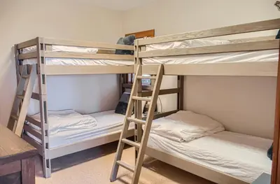 two bunk beds in a room with a desk at Moonshine Crescent 365 by Okanagan Premier in Big White