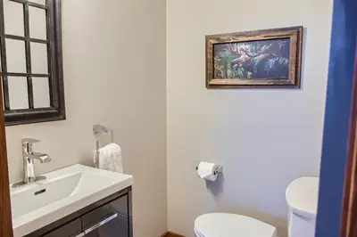 a bathroom with a white sink and a toilet at Moonshine Crescent 365 by Okanagan Premier in Big White