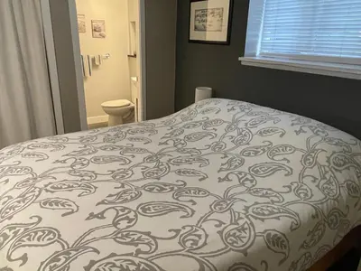 a bed in a bedroom with a blanket on it at Hastings Sunrise Experience in Vancouver