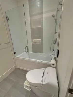 a bathroom with a white toilet and a shower at Two King Bedroom w Bath&Living Room in Vancouver