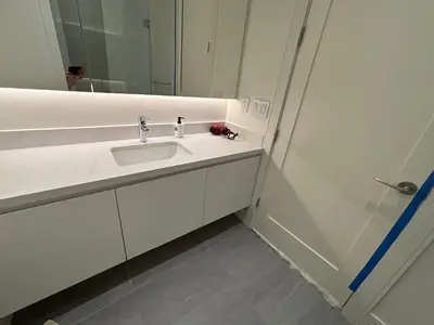 a white bathroom with a sink and a mirror at Two King Bedroom w Bath&Living Room in Vancouver