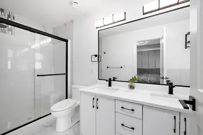 a white bathroom with a toilet and a mirror at The Happy place - Luxurious, Cozy and Modern Home with 4 bedroom Air-condition, Netflix, Free Parking close to Airport and West Edmonton Mall in Edmonton