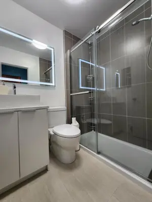 a bathroom with a toilet and a glass shower at 2-bed house for downtown, stampede & mountains in Calgary