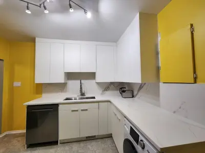 a kitchen with white cabinets and a dishwasher at 2-bed house for downtown, stampede & mountains in Calgary
