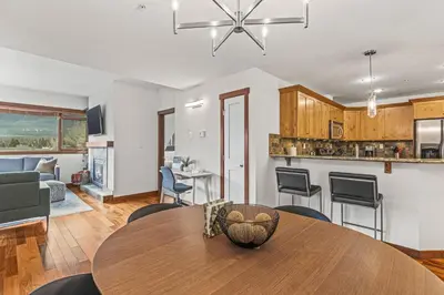 a dining room and kitchen with a table and chairs at Skyline Suite Downtown Canmore Stay in Canmore