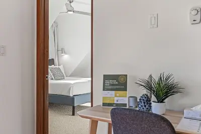 a room with a desk and a bedroom with a bed at Skyline Suite Downtown Canmore Stay in Canmore