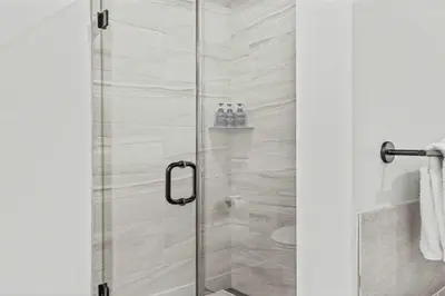 a shower with a glass door in a bathroom at Stylishly Renovated Spring Creek Retreat in Canmore