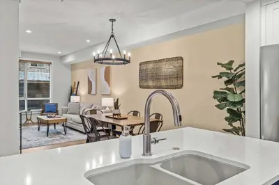 a kitchen with a sink and a living room at Stylishly Renovated Spring Creek Retreat in Canmore