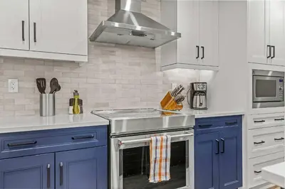 a kitchen with blue cabinets and a stove top oven at Stylishly Renovated Spring Creek Retreat in Canmore