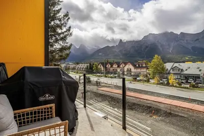 a bench with a view of a town and mountains at Scenic Views in a Luxurious Townhouse in Canmore