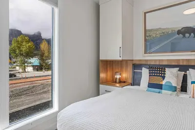 a bedroom with a bed and a large window at Scenic Views in a Luxurious Townhouse in Canmore