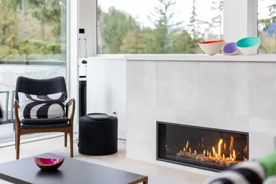 a living room with a fireplace and a chair at #9111 Wedgewoods in Whistler