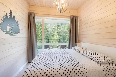 a bedroom with a bed and a large window at #9111 Wedgewoods in Whistler