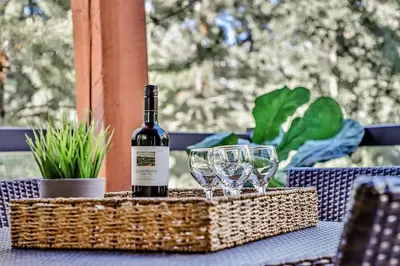 a bottle of wine sitting on a table with glasses at Woodland Retreat 2 Bedroom in Canmore