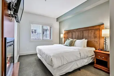 a bedroom with a large white bed and a window at Woodland Retreat 2 Bedroom in Canmore