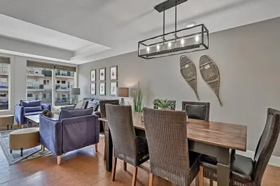 a dining room and living room with a table and chairs at Classic Hideaway Elegant 2BD 2BTH in Canmore