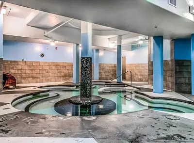a swimming pool with a fountain in the middle of a building at Classic Hideaway Elegant 2BD 2BTH in Canmore