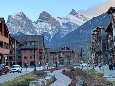 a street in a town with mountains in the background at Family Gateway Outdoor Pool & Hot Tub Experience in Canmore