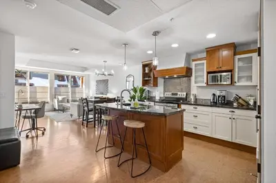 a kitchen with white cabinets and a island with bar stools at Quiet Retreat for Couples in Canmore