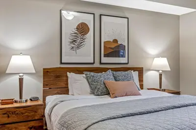 a bedroom with a bed with three pictures on the wall at Alpine Serenity in Canmore in Canmore