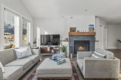 a living room with a couch and a fireplace at Spectacular Rocky Mountain Views 3BD in Canmore