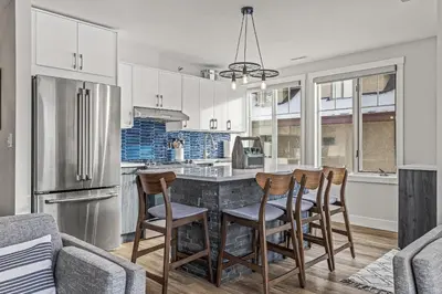 a kitchen with a table with chairs and a refrigerator at Spectacular Rocky Mountain Views 3BD in Canmore