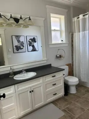 a bathroom with a sink and a toilet and a mirror at Bright Spacious Entire Home with Kids Backyard Set in Victoria
