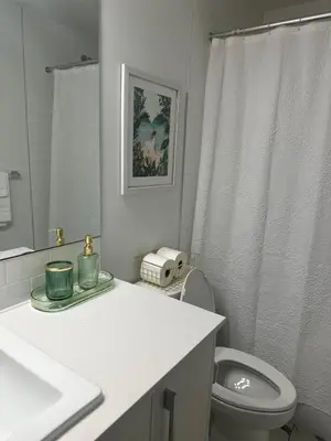 a white bathroom with a toilet and a sink at A Cozy Private Suite in Rangeview, SE Calgary in Calgary