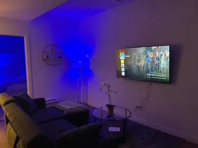 a living room with a tv on a purple wall at A Cozy Private Suite in Rangeview, SE Calgary in Calgary