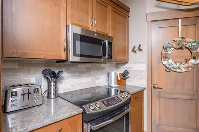 a kitchen with a stove and a microwave at Stonegate Resort Unit B206 in Kelowna