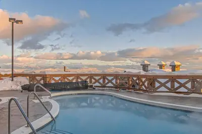 a swimming pool with a view of the snow covered mountains at Stonegate Resort Unit B206 in Kelowna