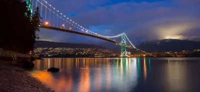 a bridge over a body of water at night at Stunning Skyline Views in a Cozy and Stylish Abode in Vancouver