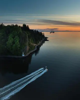 a boat in a body of water at sunset at City Retreat With Views in the Heart of Downtown in Vancouver