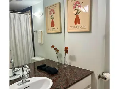 a bathroom with a sink and a toilet and a mirror at City Retreat With Views in the Heart of Downtown in Vancouver