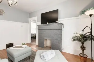 a living room with a fireplace with a flat screen tv at Ceruleans 3BR Suite in Calgary in Calgary
