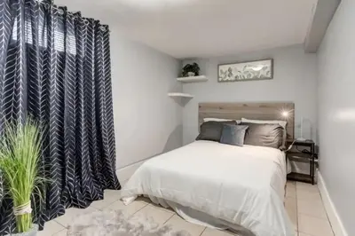 a bedroom with a bed and a black and white curtain at Ceruleans 3BR Suite in Calgary in Calgary