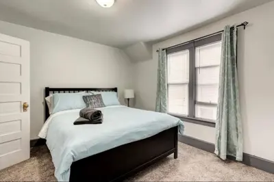 a bedroom with a bed with a hat on it at Oakwoods 1BR Suite in Bankview in Calgary