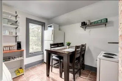 a kitchen with a table with chairs and a refrigerator at Oakwoods 1BR Suite in Bankview in Calgary