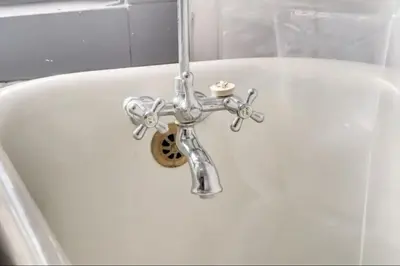 a bath tub with a silver faucet in a bathroom at Oakwoods 1BR Suite in Bankview in Calgary