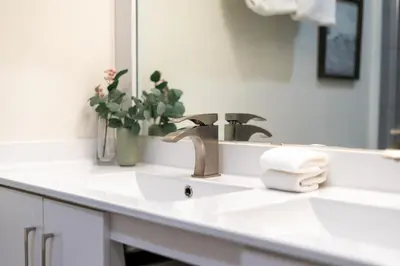 a bathroom sink with a faucet and a mirror at Whistler Lakeside Hideaway in Whistler