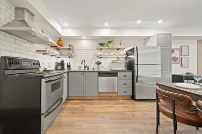 a kitchen with stainless steel appliances and a table at Whistler Lakeside Hideaway in Whistler