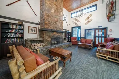a living room with a large stone fireplace at Whistler Lakeside Hideaway in Whistler