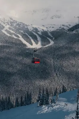 a red ski lift flying over a snow covered mountain at Whistler Lakeside Hideaway in Whistler