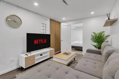 a living room with a couch and a tv at Luxury Suite, Steps to Calgary DT, River, Hospital in Calgary