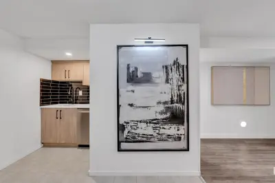 a white room with a black and white picture on a wall at Luxury Suite, Steps to Calgary DT, River, Hospital in Calgary