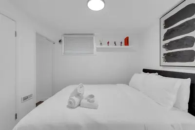 a bedroom with a white bed with shoes on it at Luxury Suite, Steps to Calgary DT, River, Hospital in Calgary