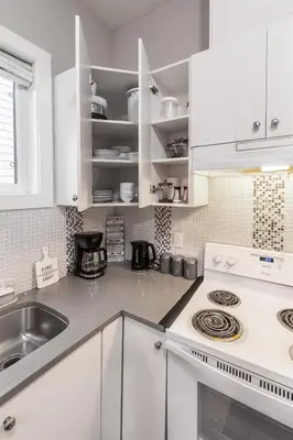 a white kitchen with a sink and a stove at Peaceful 2 Bedroom Suite that sleeps 4 with Free Wifi ,Free parking,easily accessible to Downtown Vancouver in Surrey