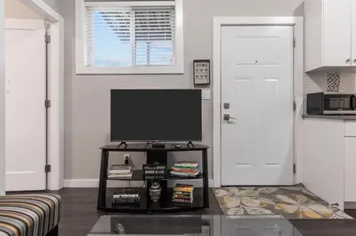 a living room with a television on a table at Peaceful 2 Bedroom Suite that sleeps 4 with Free Wifi ,Free parking,easily accessible to Downtown Vancouver in Surrey