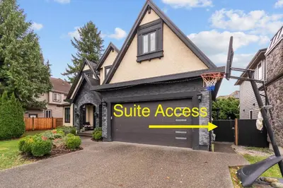 a house with a garage door with a sign that reads wife access at Peaceful 2 Bedroom Suite that sleeps 4 with Free Wifi ,Free parking,easily accessible to Downtown Vancouver in Surrey